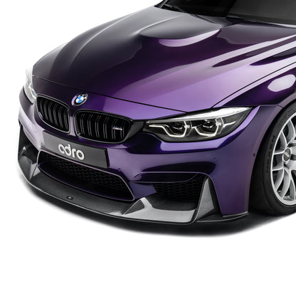 Carbon fiber front lip spoiler on BMW front bumper, close-up on dark purple car