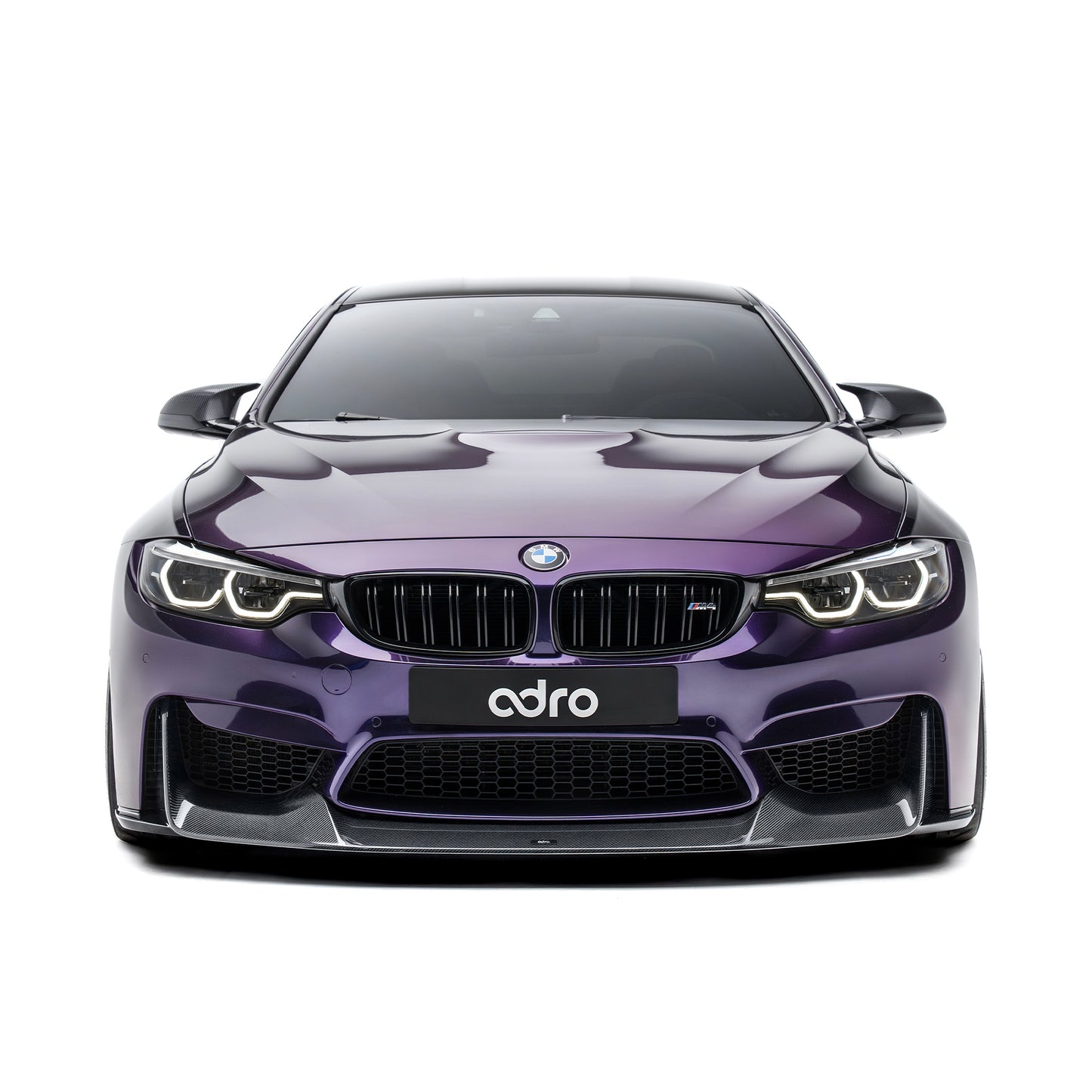 BMW front bumper lip spoiler in dark carbon fiber, front view on purple car