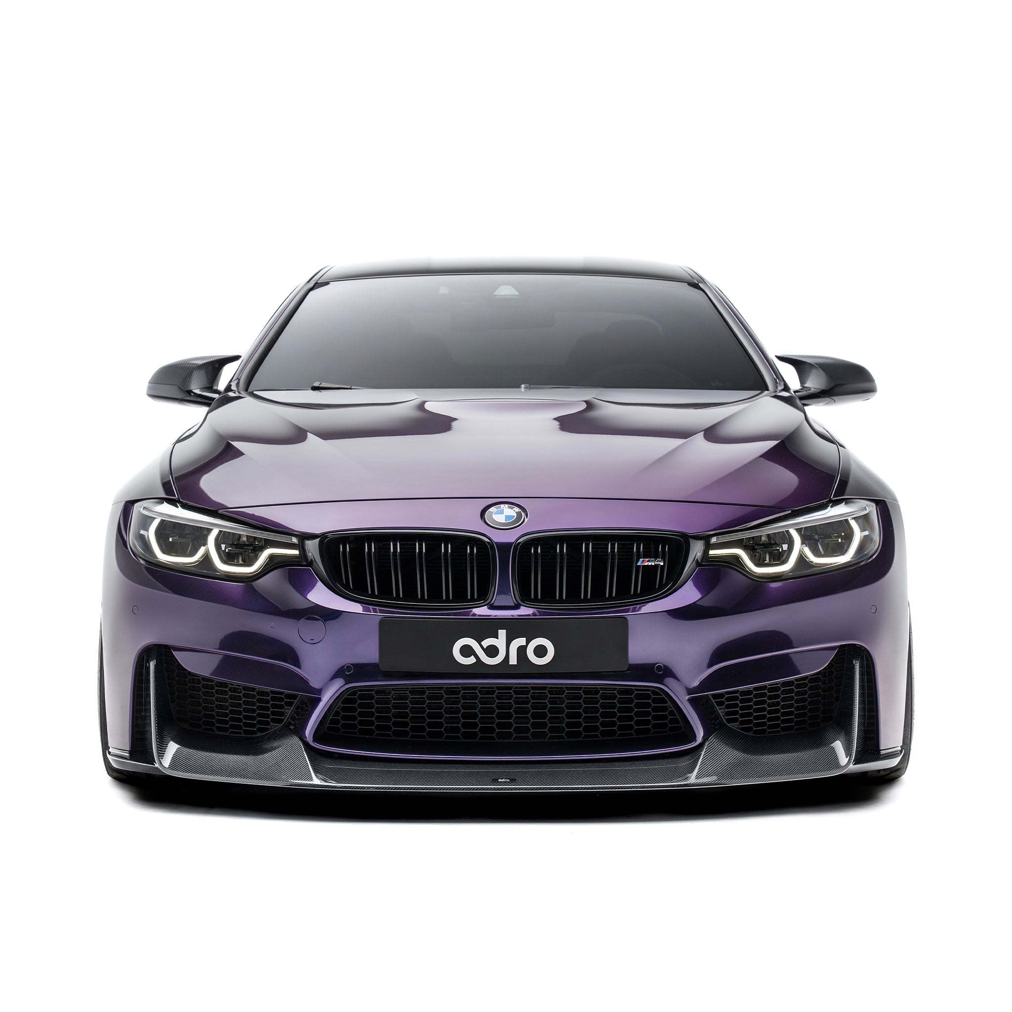 BMW front bumper lip spoiler in dark carbon fiber, front view on purple car