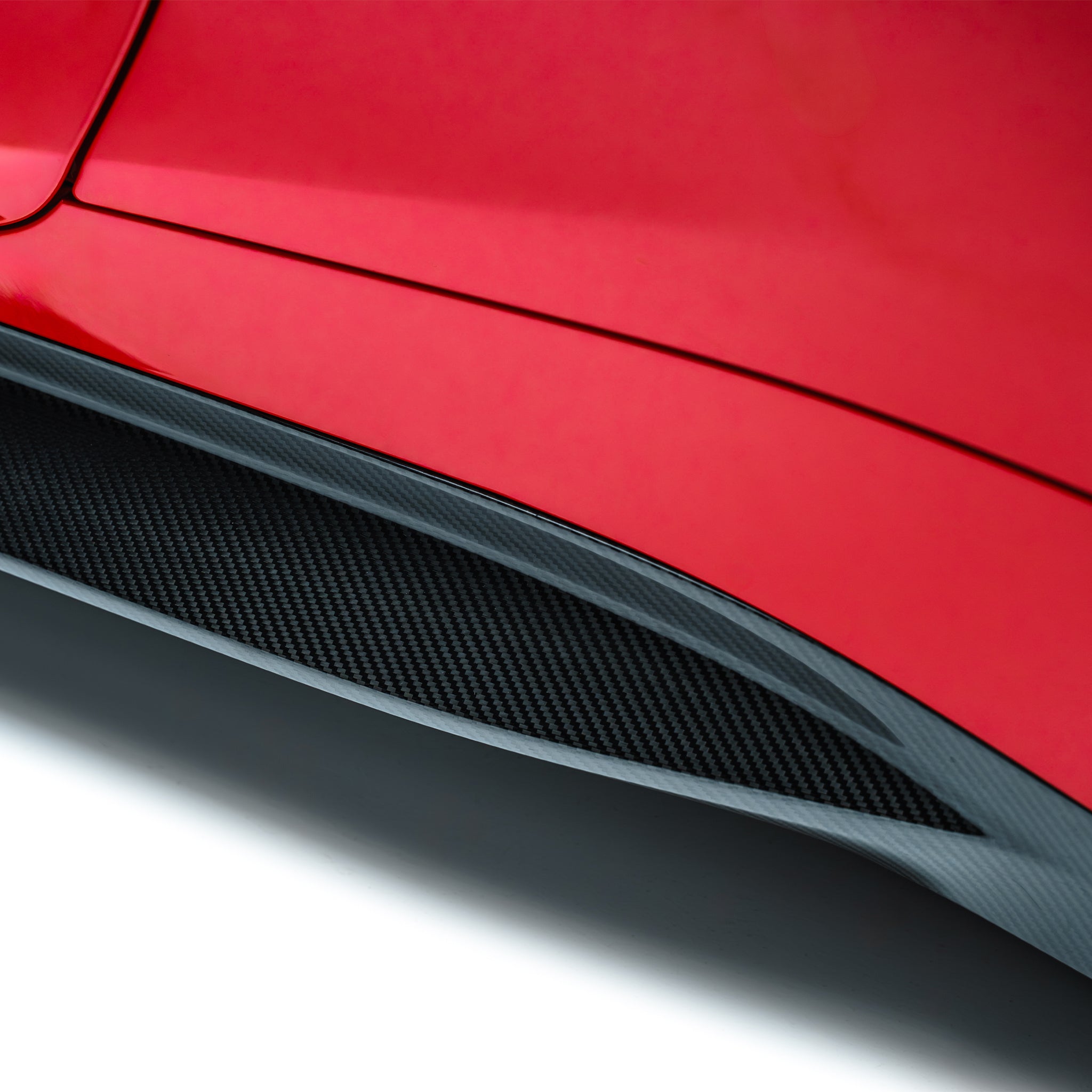 BMW M4 prepreg side skirt close-up, black carbon-fiber textured panel
