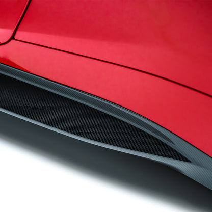 BMW M4 prepreg side skirt close-up, black carbon-fiber textured panel
